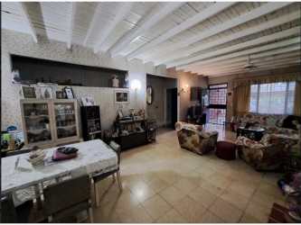 Traditional living room with exposed wood beams, floral sofas, dining area in Carrasquilla near Parque Omar
