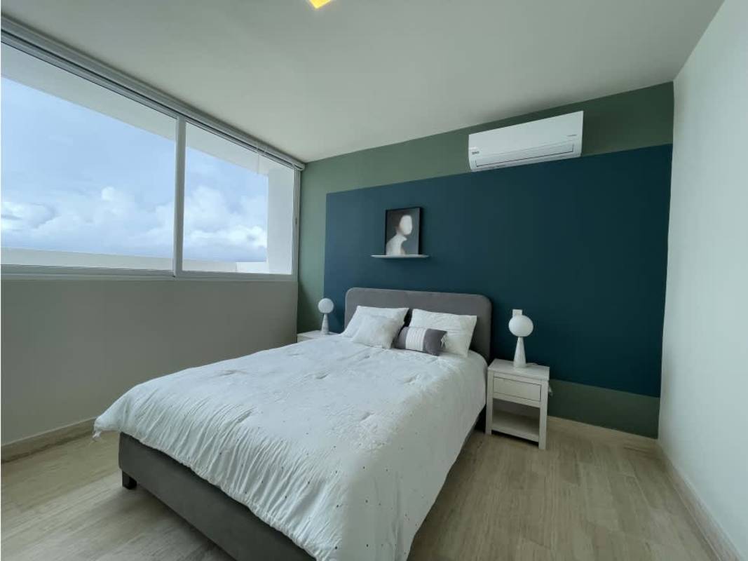Elegant bedroom featuring large window with ocean and city view at The Regent Costa del Este