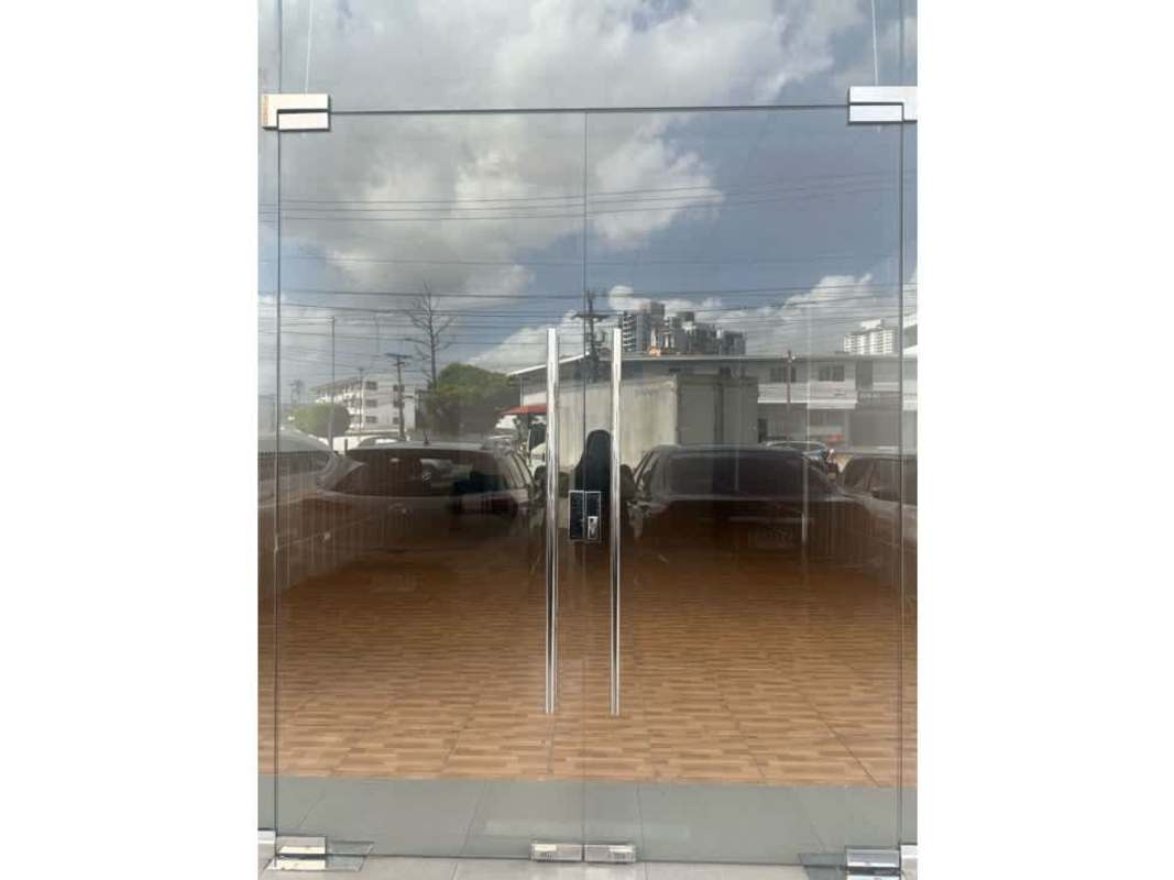 Floor-to-ceiling glass doors on commercial frontage reflecting urban street in Plaza Santa Fe, Panama City