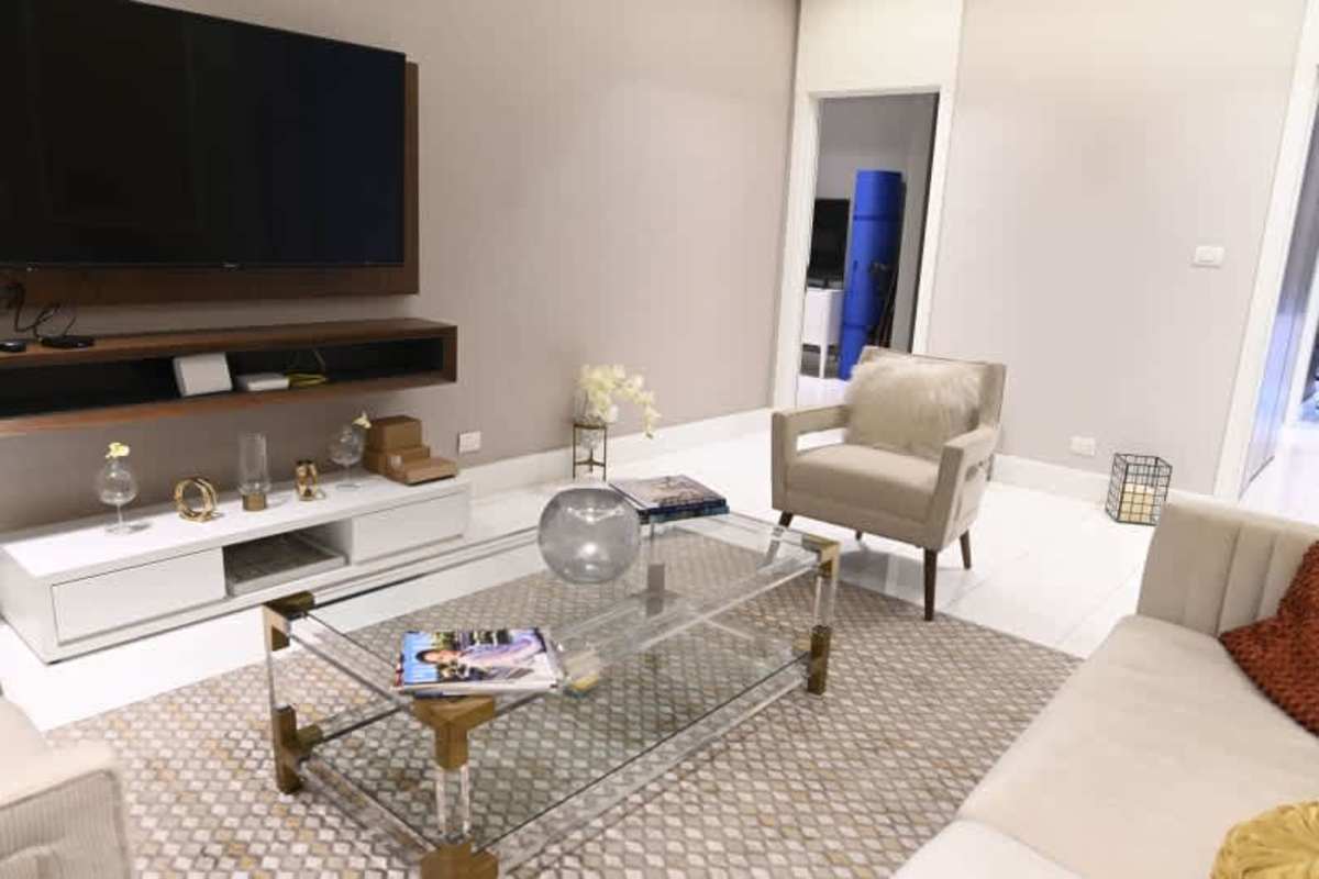 Modern living room with TV wall, beige decor and glass table at PH Ocean Waves Panama City
