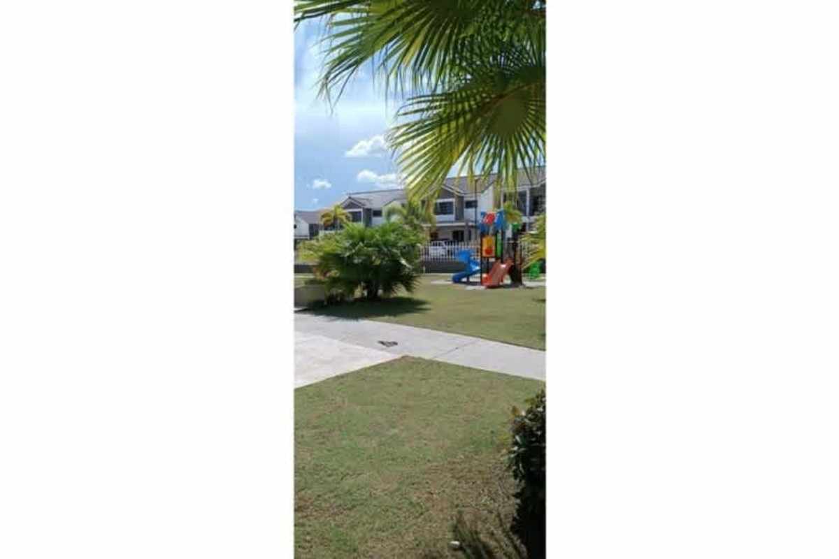 Private backyard with grass lawn, white fence and young palms Paseo del Norte Panama