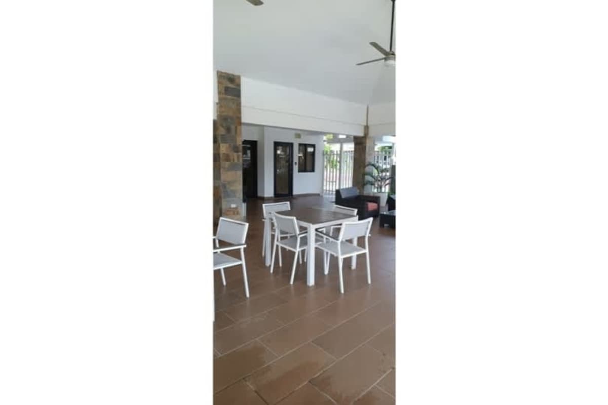 Covered terrace with furniture and tile flooring overlooking backyard garden in Paseo del Norte Panama
