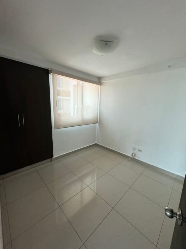 Bedroom with built-in closet, large windows offering panoramic urban skyline view at PH Mirador Bella Vista Panama