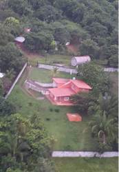 Aerial view of rural house with red roof fenced yard green landscape in Guadalupe Costa Verde Panama