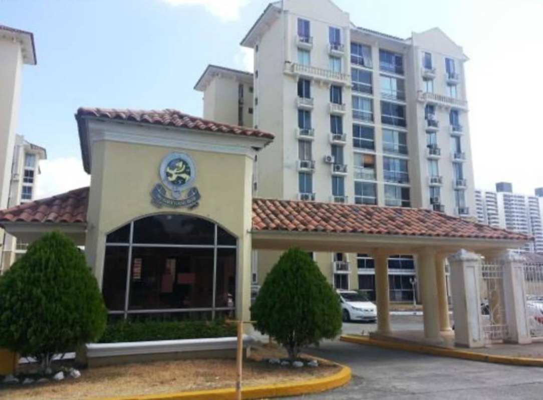 Main gated entrance with guard and Mediterranean-style buildings at PH McGregor Hill Condado del Rey Panama
