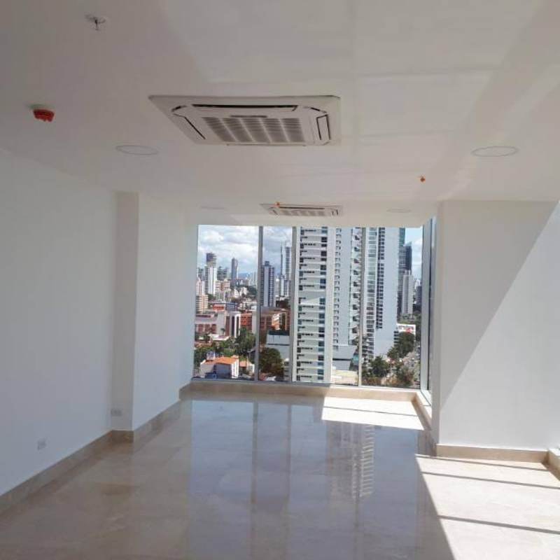 Glass tower skyscraper Balboa Office Center on Avenida Balboa with palm trees and blue sky