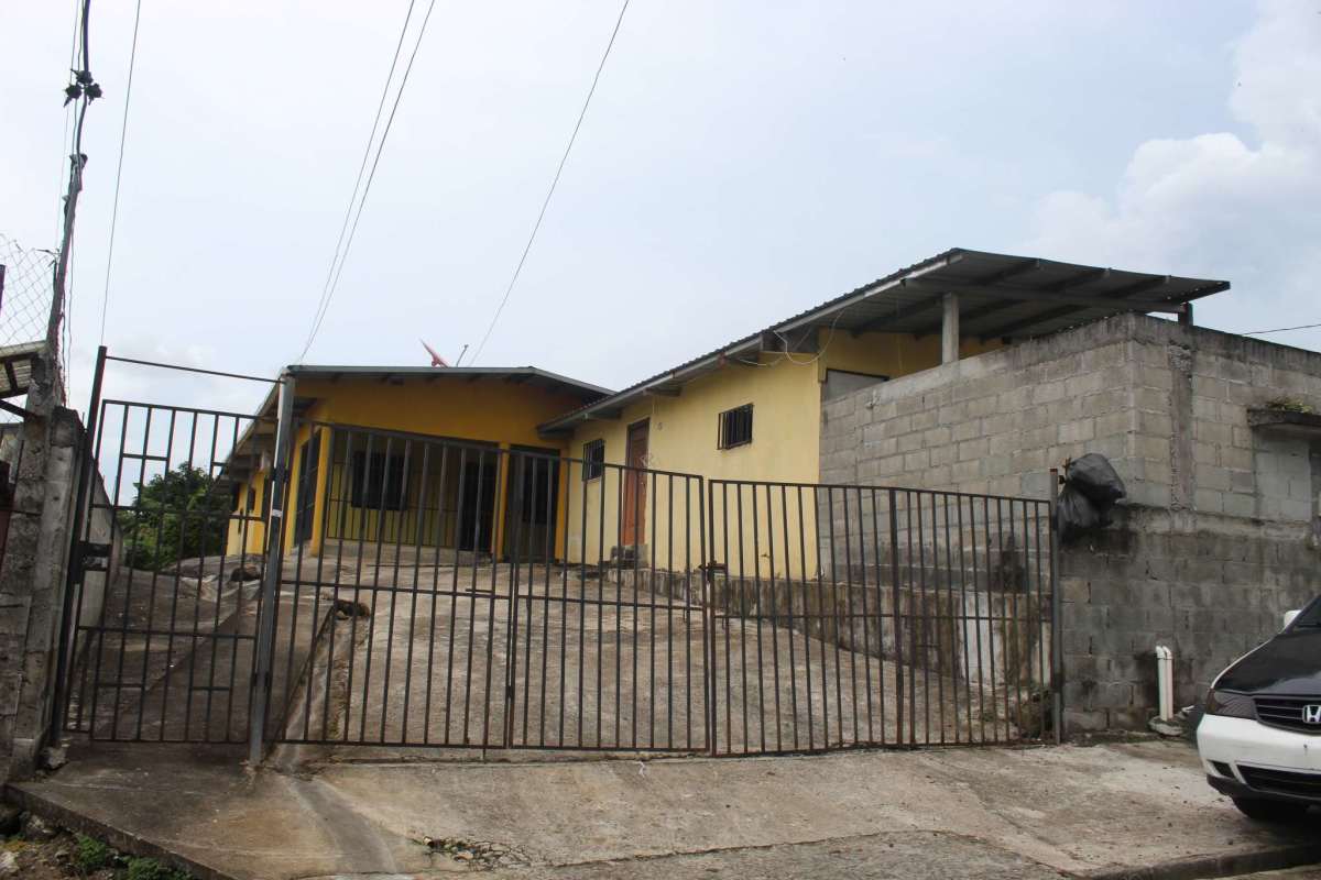 Yellow single-level house with metal gate, concrete driveway in Rana de Oro Pedregal Panama