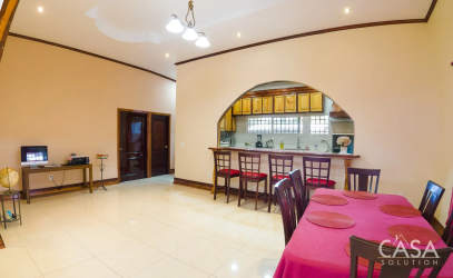 Dining room with red tablecloth arch opening to kitchen tile floors Bugaba Chiriquí Panama