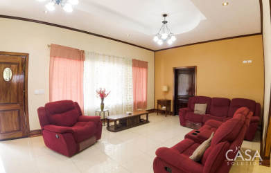 Spacious living room red recliner sofas tile floor curtains large window Bugaba Chiriquí Panama