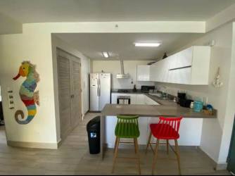 Fully equipped open kitchen with white cabinets in beach condo Playa Caracol Panama