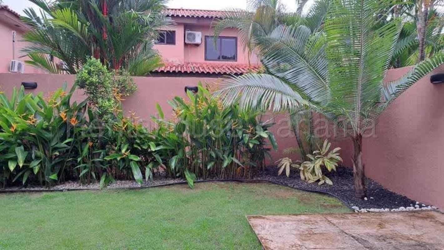 Covered back terrace and garden lawn in Versalles II Costa Sur house