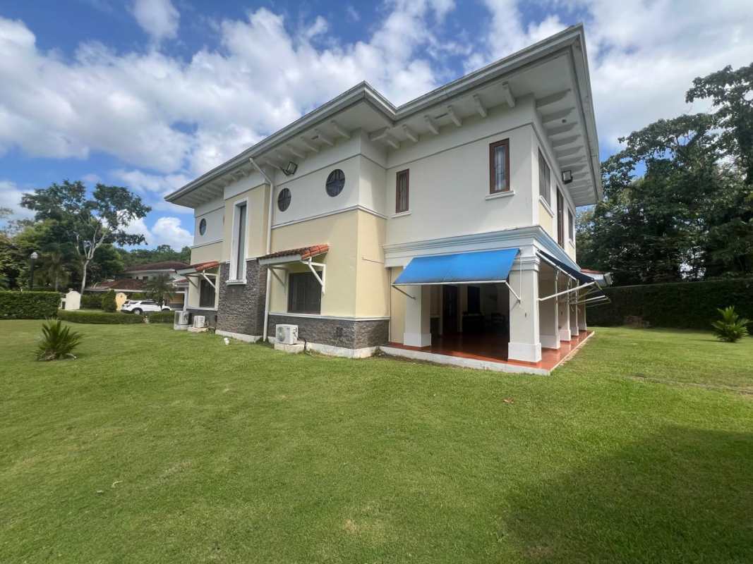 Mediterranean-style luxury house with blue awnings, large lawn and mature trees in Clayton Panama