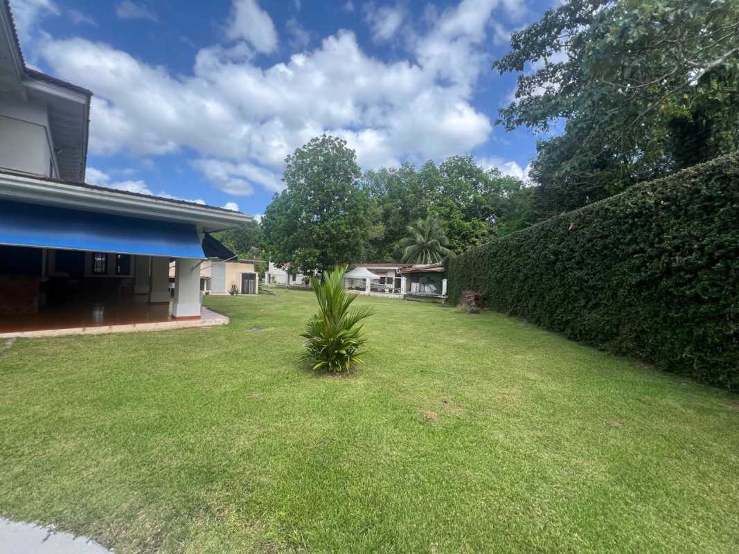 Manicured green park with walking paths, benches, lampposts surrounded by mature trees Residencial Camino de Cruces