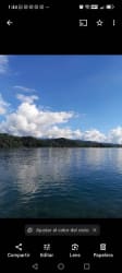 Calm Caribbean waters with forest and clouds from Isla Grande beachfront Panama