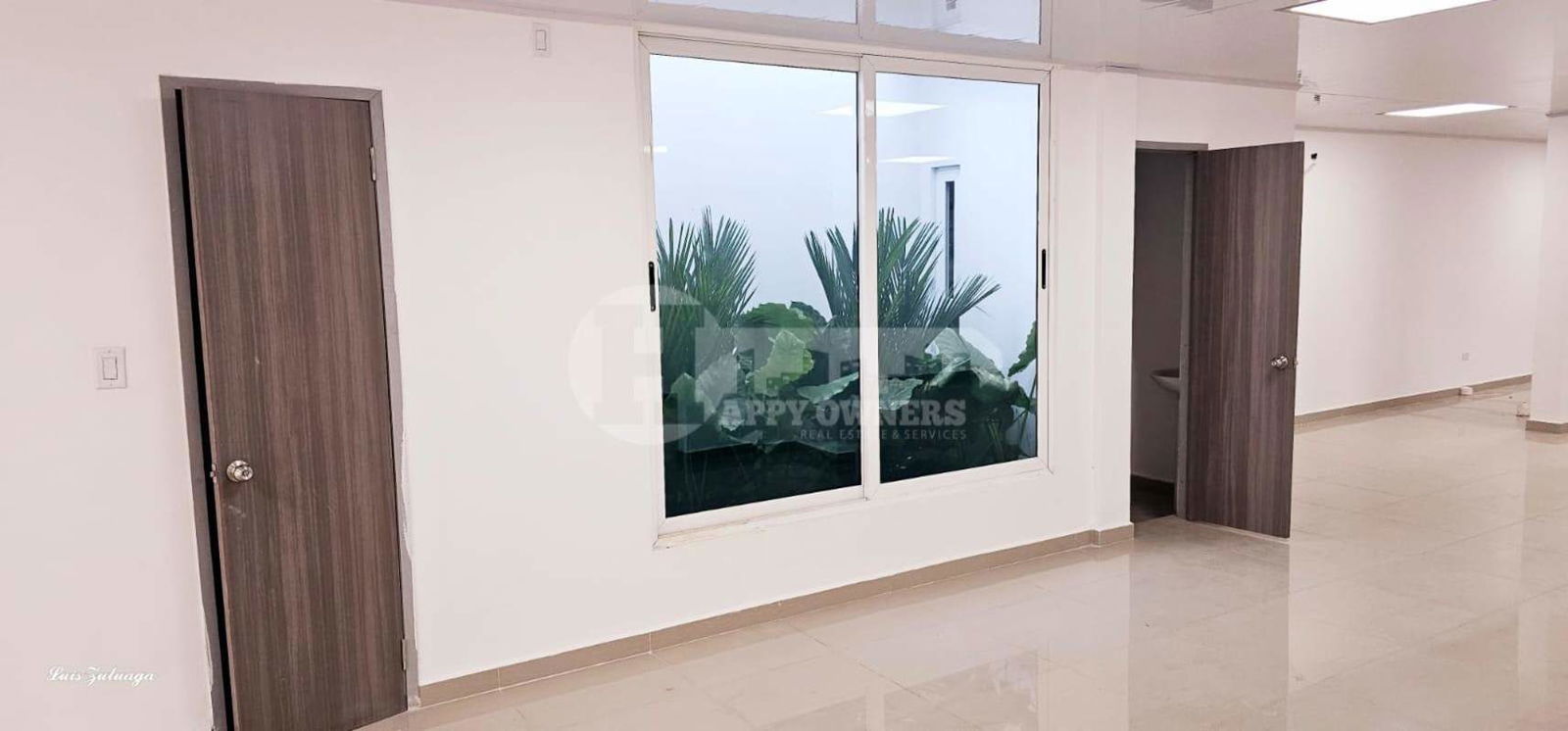 Modern hallway with glass entrance doors, tiled floors in commercial plaza Chanis Panama