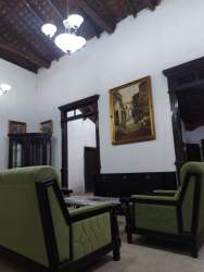 Living room with wooden accents, green sofas and colonial decor in Los Santos Panama