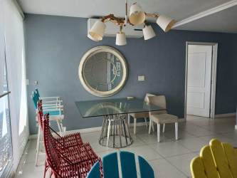 Contemporary dining room with colorful chairs and blue accent wall in PH Coral Park Panama