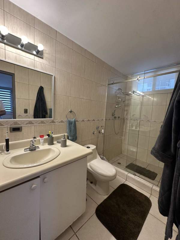 Contemporary bathroom with glass shower enclosure and vanity sink at PH Sky View