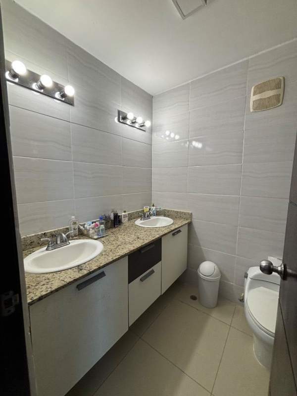 Double vanity bathroom with granite countertop large mirror tiled walls Albrook Condo Clayton Panama