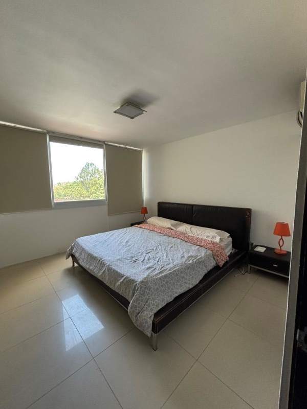Bedroom with king size bed, tile floor, large windows, and lamps in Clayton Park Residences Panama City
