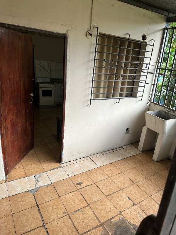 Tile-floored utility zone with sink and kitchen stove beyond Villa Lobos Pedregal
