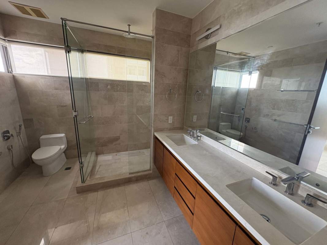 Luxury bathroom with double sink marble vanity, glass shower enclosure, modern fixtures in PH The Reserve