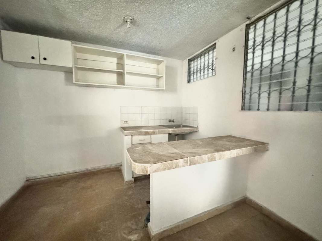 Small simple kitchen with tile counter and open shelves in Rio Abajo Panama