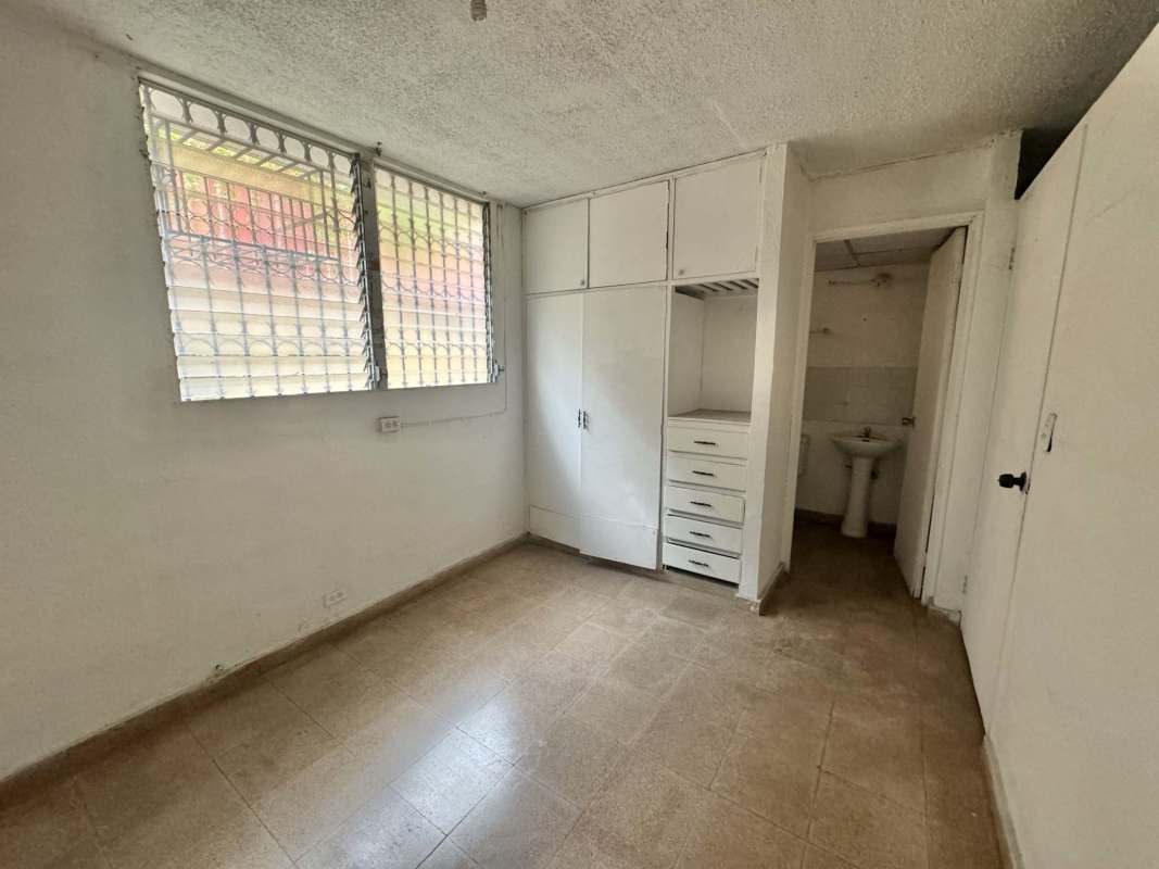 Bedroom with built-in wardrobe, barred windows and attached bathroom Panama City
