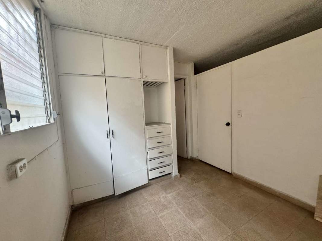Bedroom with closet, barred window, tile floor in budget apartment Rio Abajo Panama