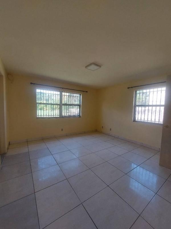 Empty bedroom with large windows overlooking greenery in Clayton Panama City apartment