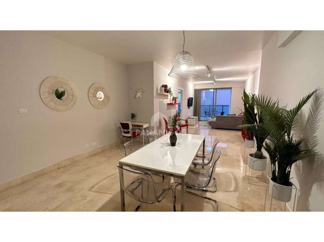 Modern open kitchen with quartz counters, island, stainless appliances and stylish dining area in Yoo Panama