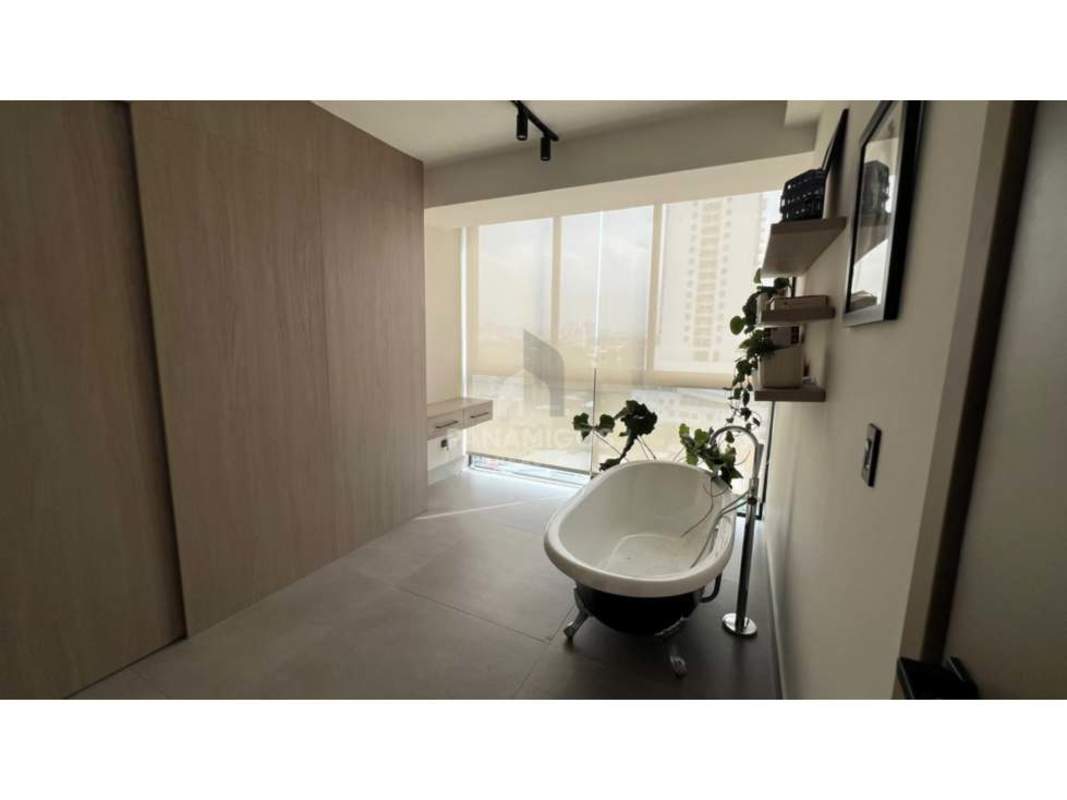 Modern luxury bathroom with standalone bathtub and large window overlooking Panama City in Victory Wellness
