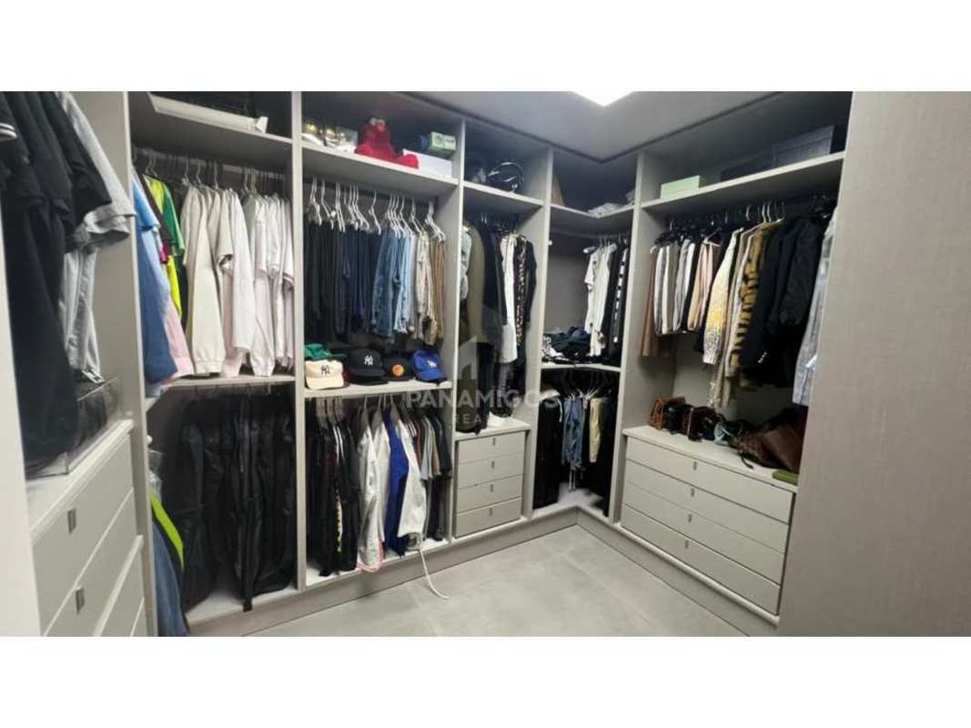 Modern walk-in closet with built-in shelves and drawers in Victory Wellness Coco del Mar Panama apartment