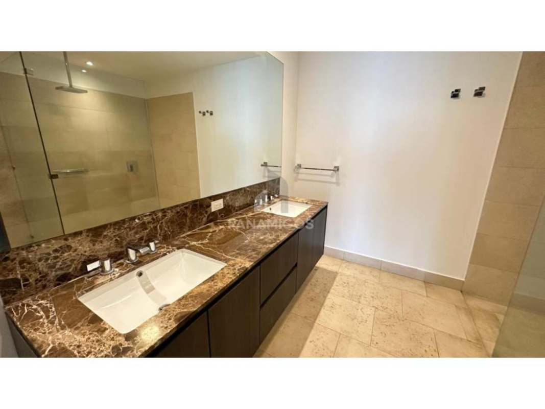 Elegant modern bathroom with double sink vanity marble top glass shower The Ocean Club Punta Pacífica Panama