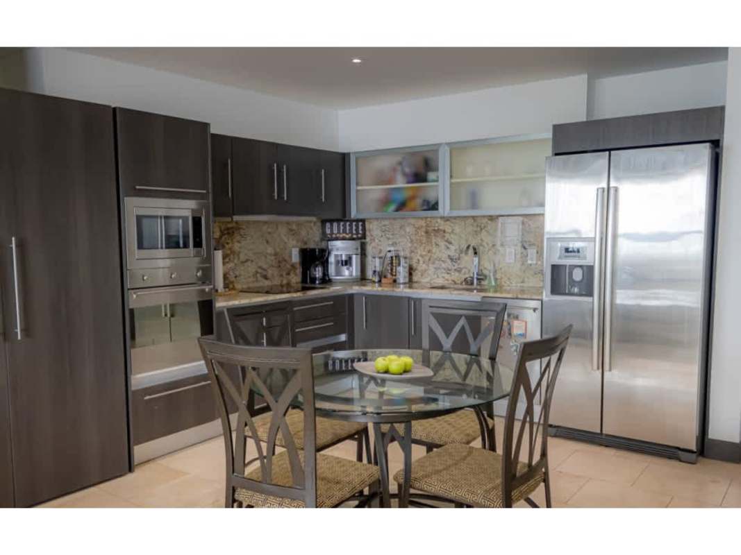 Modern kitchen with granite counters, stainless appliances and dining area at The Ocean Club Panama City