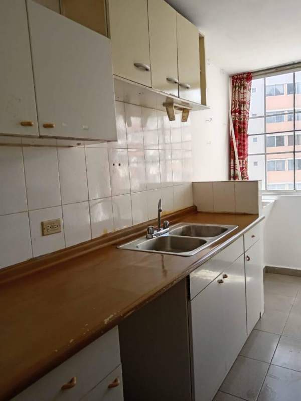 Kitchen with dual stainless sink white cabinets tiled backsplash red curtains Juan Díaz apartment Panama