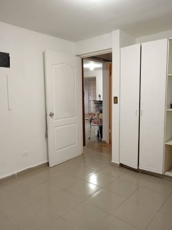 Bedroom with built-in white wardrobe, tile floors, white walls, affordable apartment in Juan Díaz Panama
