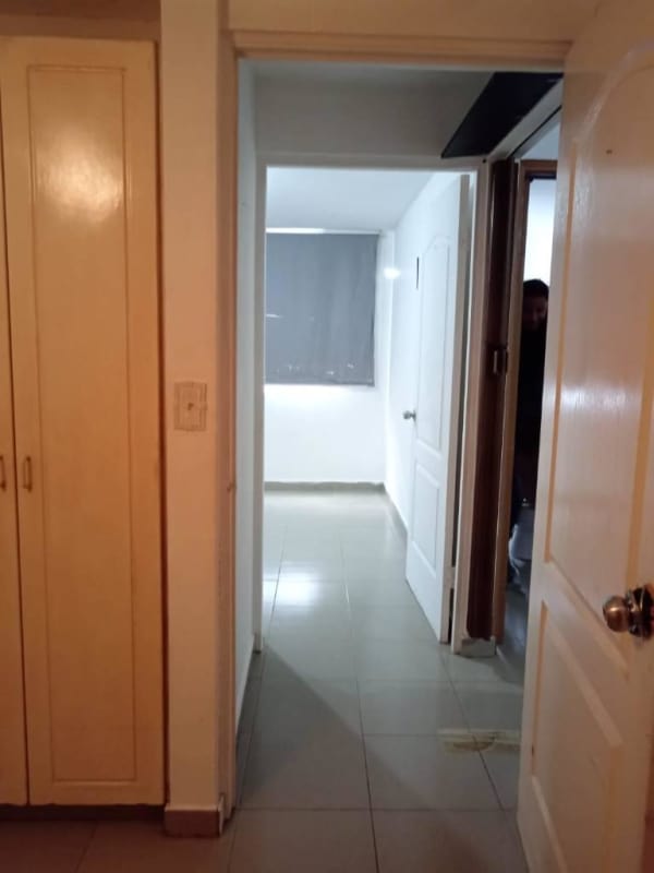 Hallway with tile flooring, multiple doors, window with roller blind inside affordable Juan Díaz apartment