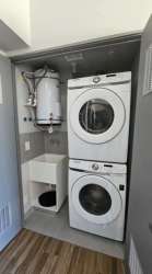 Laundry closet with stacked washer dryer, tankless water heater in apartment at PH Mosaic Panama Pacifico