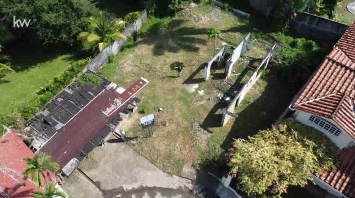 Cleared lot beside tiled roof houses aerial Panama City San Francisco neighborhood