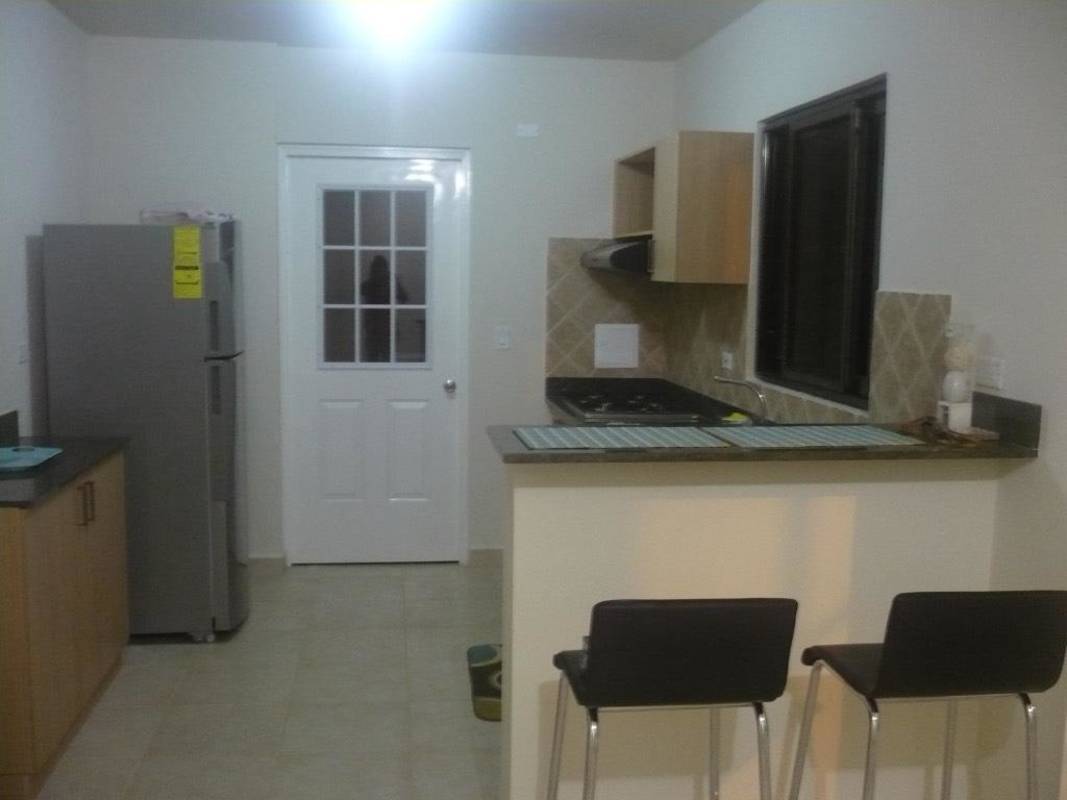 Contemporary kitchen with granite countertops, breakfast bar and stainless appliances at Versalles Costa Sur