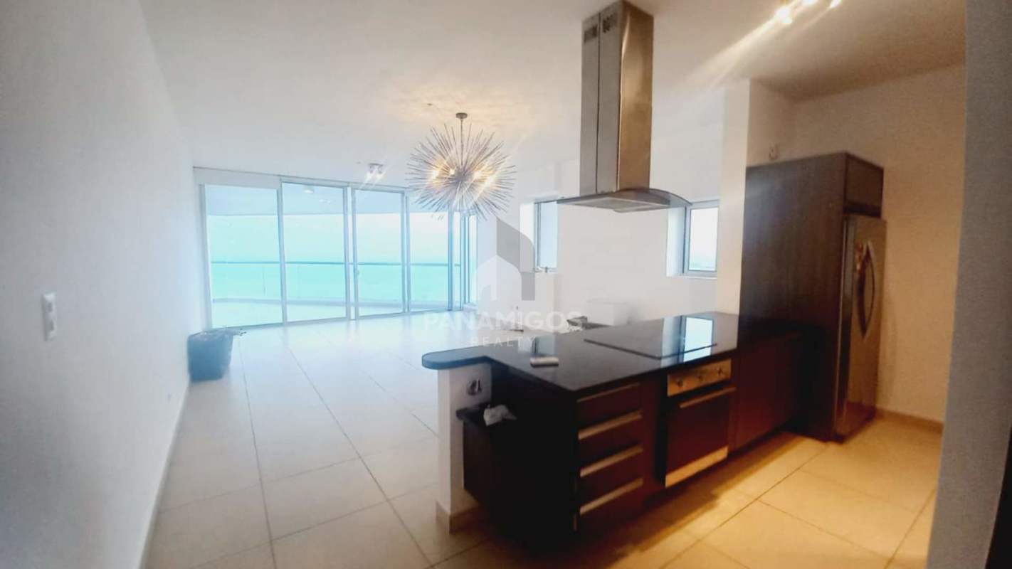 Modern open-plan kitchen and living area with floor-to-ceiling glass and ocean view in PH Rivage Tower Panama