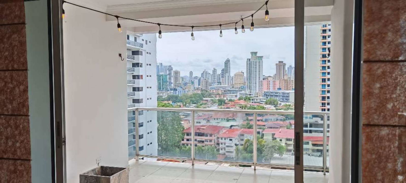 Balcony with glass railing, tile floors, overlooking buildings PH Fairmont Plaza Panama City