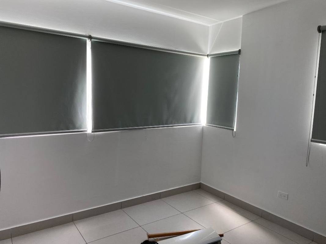 Living area with large windows and roller blinds empty in PH Tee One near Parque Omar Panama City