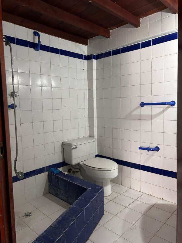 Large living space with white tiled floor, wood trim, and partition wall inside Obarrio Bella Vista duplex Panama