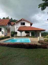 Dining room with wood beams, panoramic windows, large wooden table in country farmhouse Sora Panama