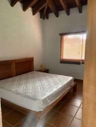 Rustic bedroom with exposed ceiling beams, wooden furnishings in farmhouse Sora Panama