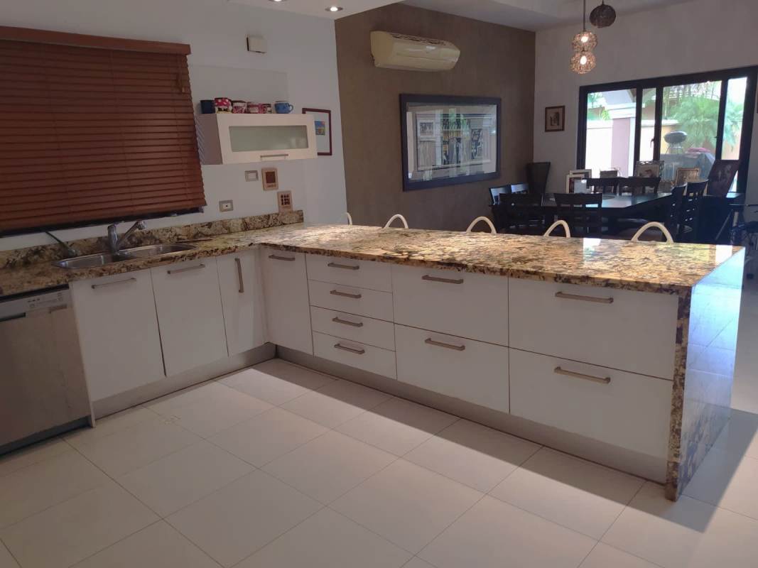 Modern kitchen with granite island, stainless appliances, breakfast bar in Sunset Coast Costa Sur Panama