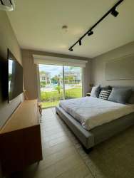 Compact modern kitchen with granite countertop and white cabinets at Playa Caracol