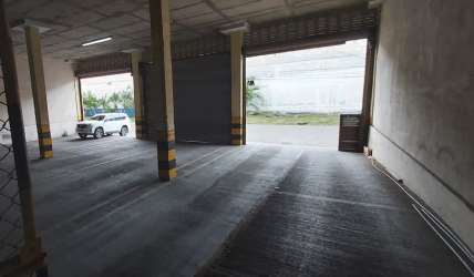 Interior of warehouse with open roller doors and support columns Zona Libre Panama